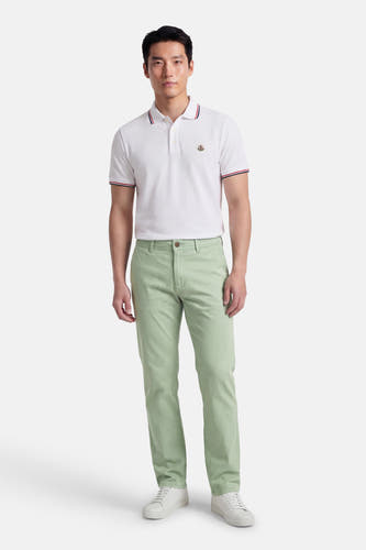 Chino vert kaki de JACK & JONES JEANS INTELLIGENCE, avec jambes droites et fermeture à boutons, combiné avec un polo blanc et des baskets blanches.