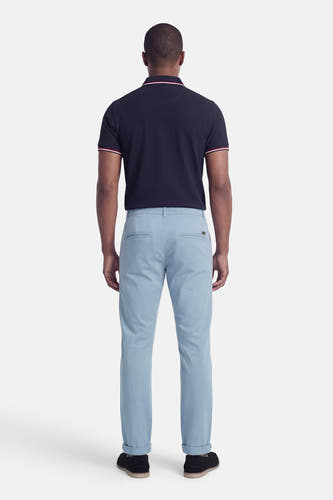 Blauwe chino van JACK & JONES JEANS INTELLIGENCE, gezien van achteren, met opgerolde pijpen en zwarte schoenen.