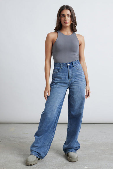 Grijze body van 24 colours, gedragen met wijde jeans en chunky schoenen.
