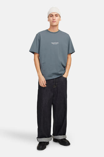 Blauw T-shirt met korte mouwen van ORIGINALS BY JACK & JONES, gedragen met een witte muts, donkere jeans en zwarte schoenen.