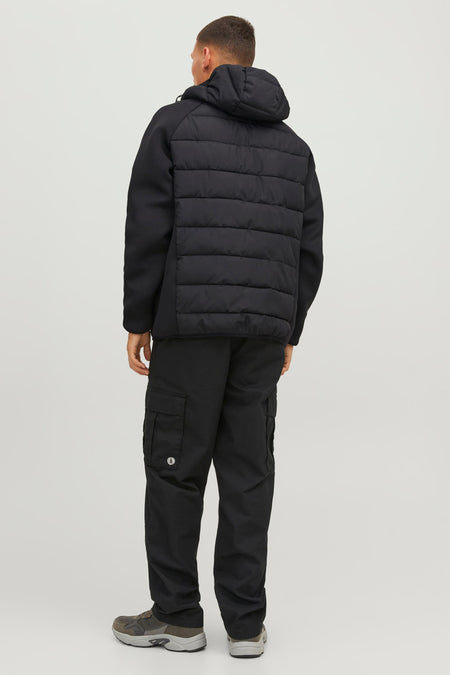Veste noire avec dos rembourré et capuche de CORE BY JACK & JONES, vue de dos, texture matelassée, le mannequin porte un pantalon noir et des baskets