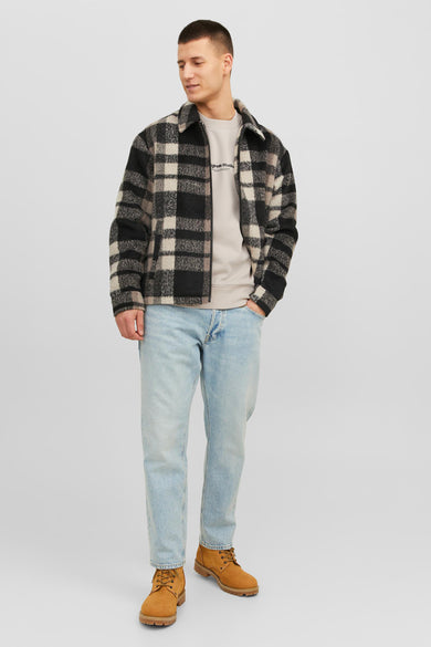 Gilet écru d'ORIGINALS BY JACK & JONES, avec un col rond, porté sous une veste ample et des jeans légers.