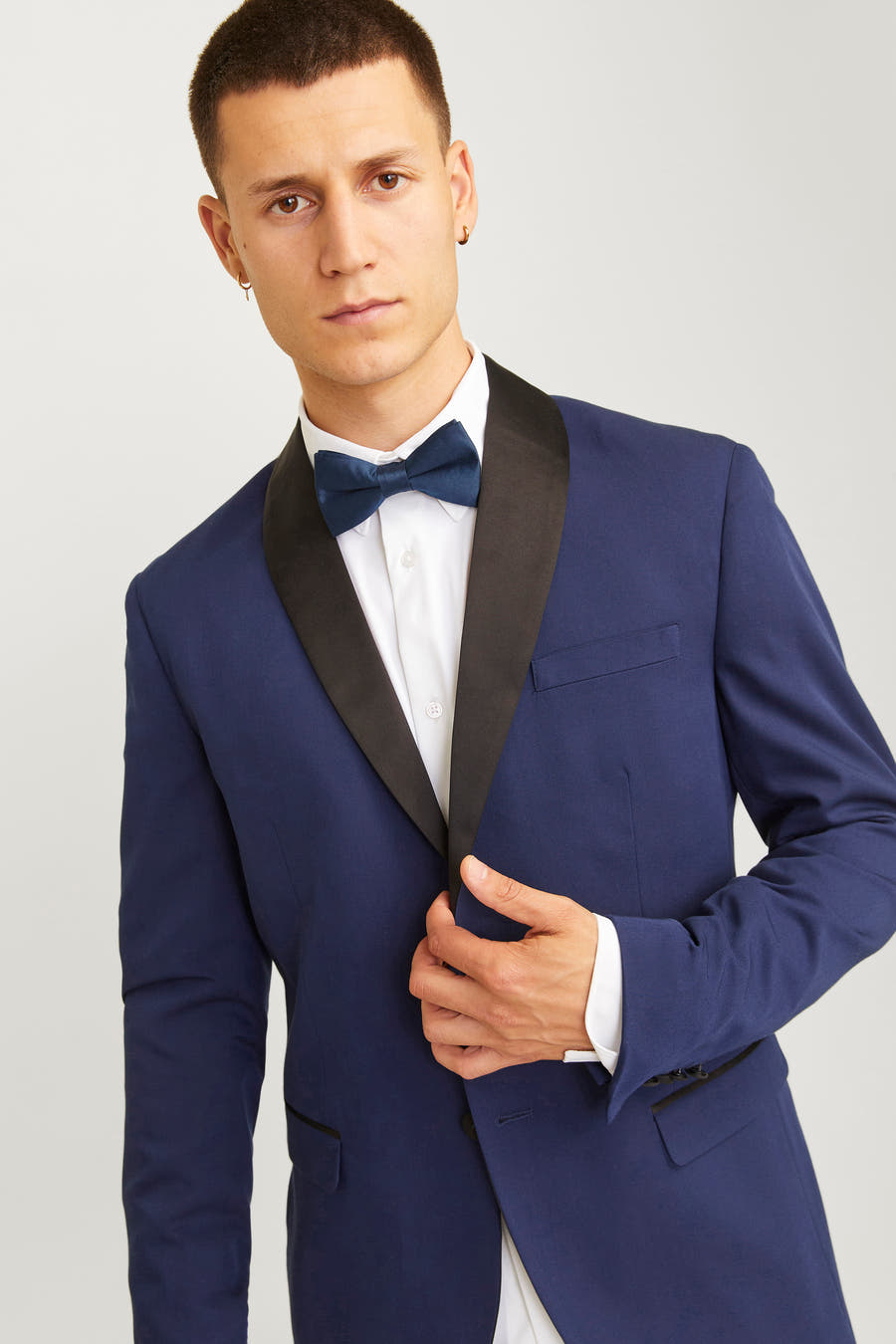 Blauw strikje van ACCESSORIES BY JACK & JONES, gedragen met een wit overhemd en blauw colbert met zwarte revers.