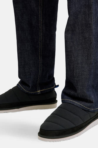 Zwarte slippers van ACCESSORIES BY JACK & JONES, met een gewatteerde bovenkant en een witte zool, gedragen met donkere jeans.
