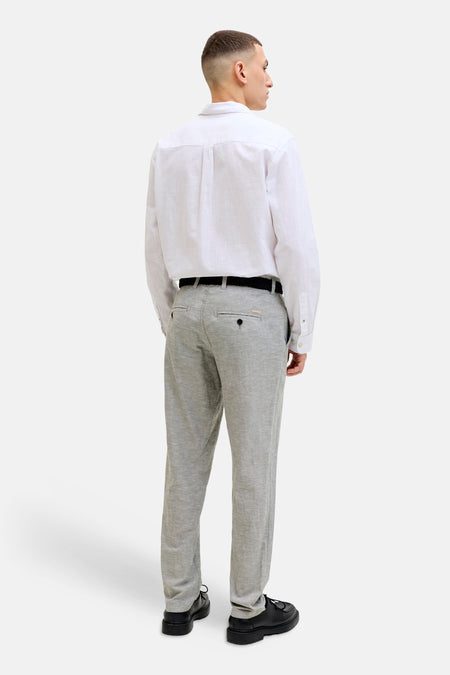 Grijze chino van JACK & JONES JEANS INTELLIGENCE, gezien van achteren, met zwarte riem en zwarte schoenen.