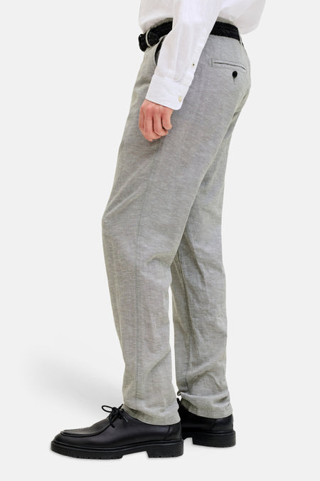 Grijze chino van JACK & JONES JEANS INTELLIGENCE, met een subtiele textuur, gestyled met een wit overhemd en zwarte schoenen.
