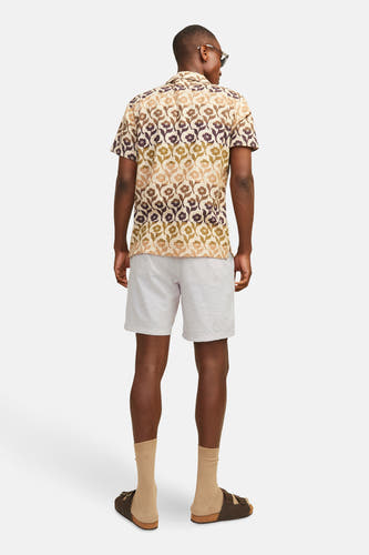 Beige short van JACK & JONES JEANS INTELLIGENCE, met lichte textuur, gecombineerd met een bloemen overhemd.
