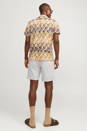 Beige short van JACK & JONES JEANS INTELLIGENCE, gedragen met een bloemenshirt, sokken en sandalen, van achteren gezien.
