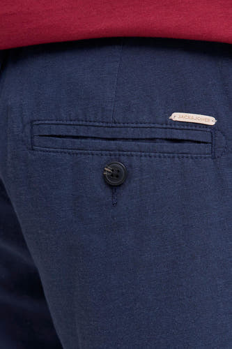 Blauwe short van geweven stof van JACK & JONES JEANS INTELLIGENCE met achterzak, knoop en lichtbruin label, erboven een rood T-shirt.