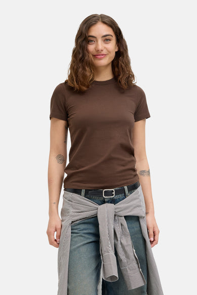 Bruin T-shirt met korte mouwen van JJXX, met nonchalant gestreepte blouse rond de taille en blauwe jeans.
