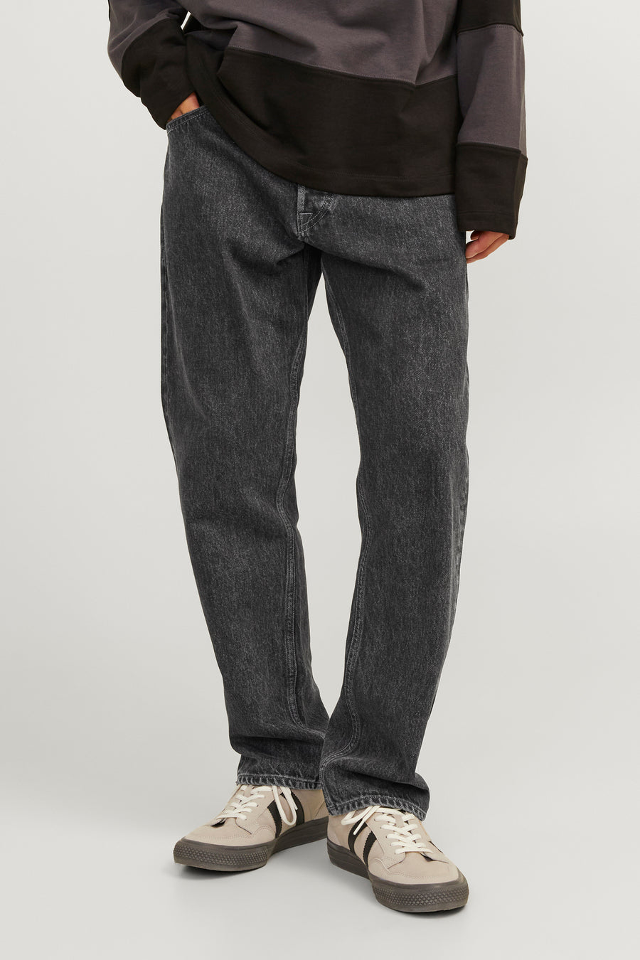 Jean délavé noir de JACK & JONES JEANS INTELLIGENCE, associé à un pull et des baskets beige.