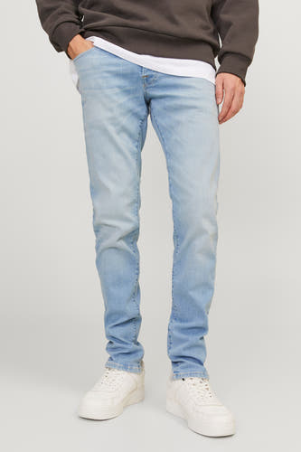 Lichtblauwe slim fit jeans van JACK & JONES JEANS INTELLIGENCE, met witte sneakers en bruine trui.
