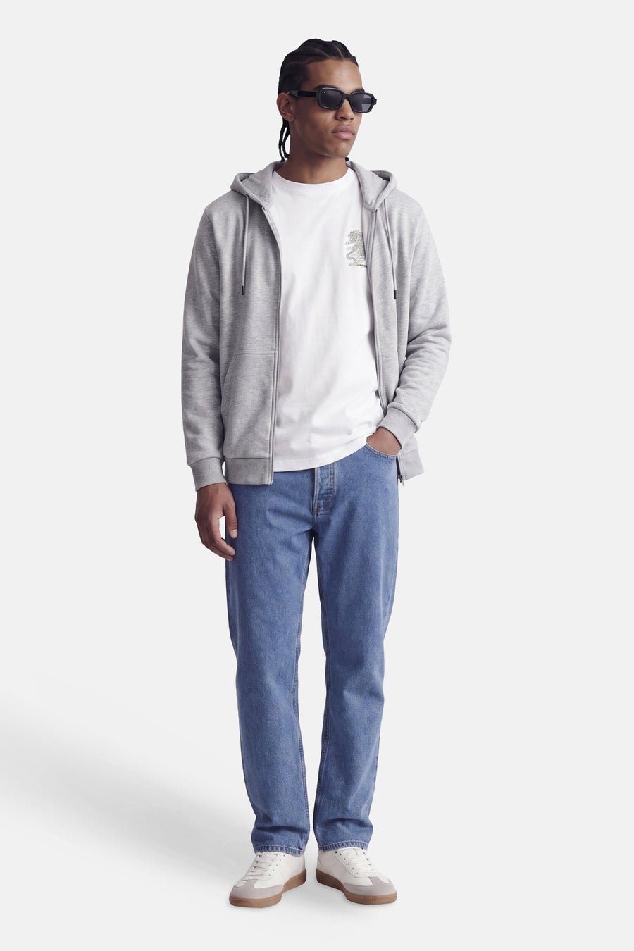 Grijze zip hoodie van CORE BY JACK & JONES, met capuchon en voorzak, gedragen over wit T-shirt, blauwe jeans en witte sneakers, front view.