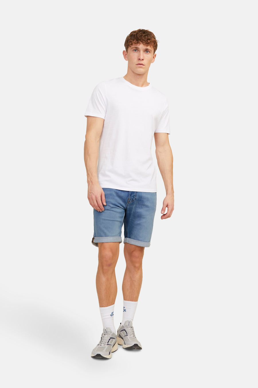 Jean court en denim bleu moyen de JACK & JONES JEANS INTELLIGENCE, avec un ourlet roulé et un t-shirt blanc.
