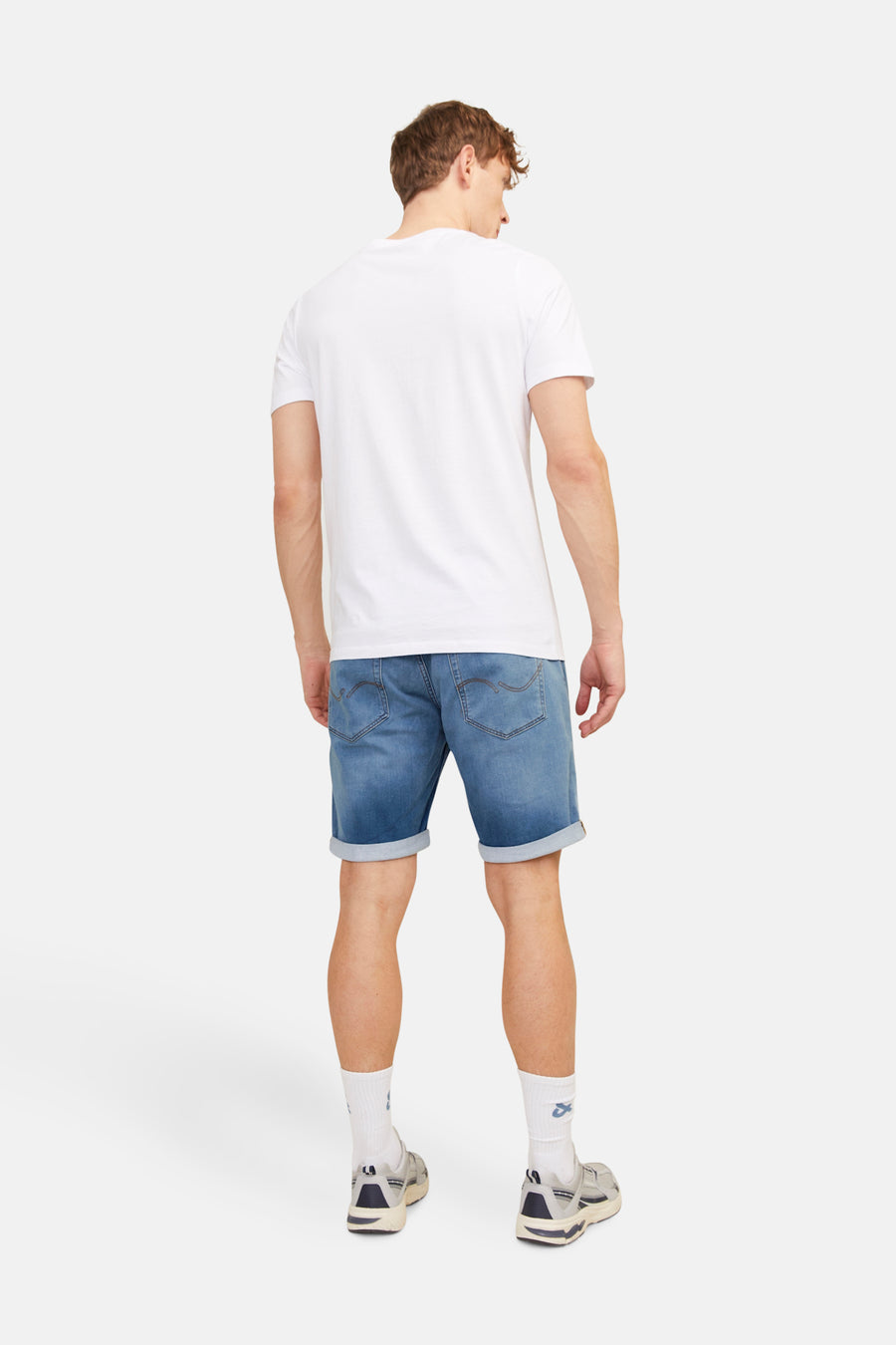 Jean en denim court bleu moyen de JACK & JONES JEANS INTELLIGENCE, vu de l'arrière, associé à des chaussettes blanches et des baskets.