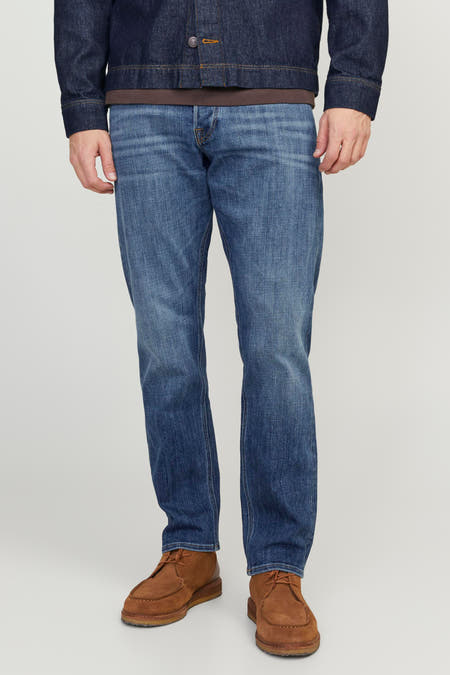 Tapered jeans van mid blue denim van JACK & JONES JEANS INTELLIGENCE, gedragen met een donkerblauw denim jack en bruine schoenen.

