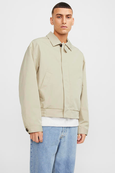 Ecru jas van ORIGINALS BY JACK & JONES, met lange mouwen, kraag en knoopsluiting, gedragen over een wit T-shirt en jeans.

