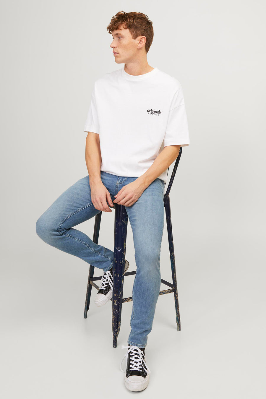Lichtblauwe skinny jeans van JACK & JONES JEANS INTELLIGENCE, gedragen met een wit T-shirt en hoge sneakers.
