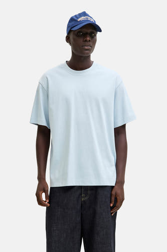 Blauw T-shirt met korte mouwen van CORE BY JACK & JONES, gedragen met een donkere broek en een blauwe pet.
