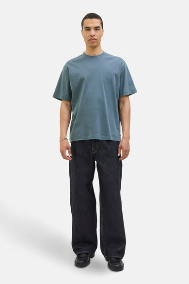 T-shirt bleu à manches courtes de CORE BY JACK & JONES, avec des jeans décontractés et des chaussures noires.