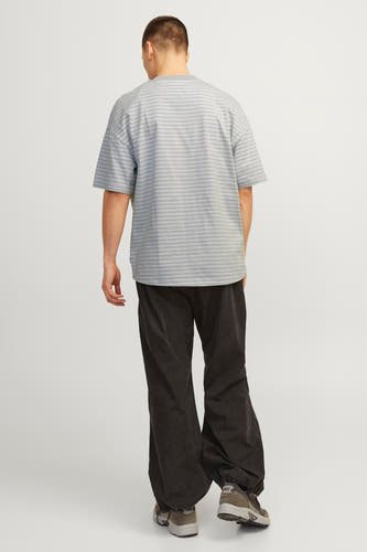 T-shirt gris à manches courtes de CORE BY JACK & JONES, avec des rayures horizontales, associé à un pantalon noir et des baskets.