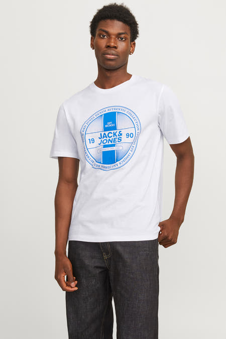 Wit T-shirt met korte mouwen van CORE by JACK & JONES, met blauwe print op de voorkant en donkere jeans.