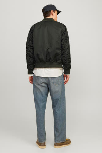 Groene jas van CORE BY JACK & JONES, met lange mouwen, gedragen over een wit overhemd en blauwe jeans.