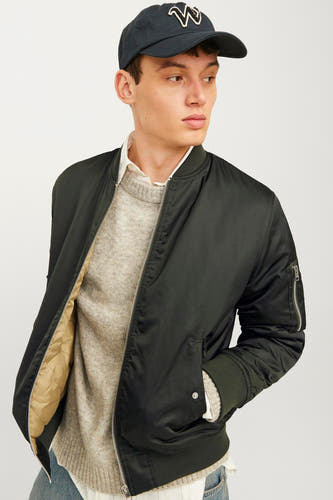 Groene jas van CORE BY JACK & JONES, met ritssluiting, zakken en een man met een pet.
