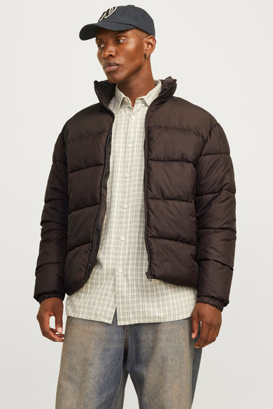 Bruine korte jas van ORIGINALS BY JACK & JONES, gedragen over een geruit overhemd met jeans en een pet.
