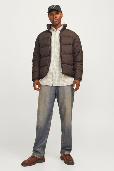 Bruine korte jas van ORIGINALS BY JACK & JONES, gedragen met een geruit overhemd, blauwe jeans en bruine schoenen.