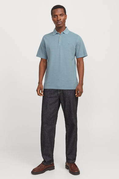 Polo bleu avec manches courtes de PREMIUM BLUE par JACK & JONES, porté avec des jeans foncés et des chaussures marrons.