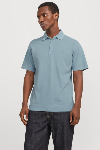 Polo bleu avec manches courtes de PREMIUM BLUE par JACK & JONES, porté avec un jean foncé.