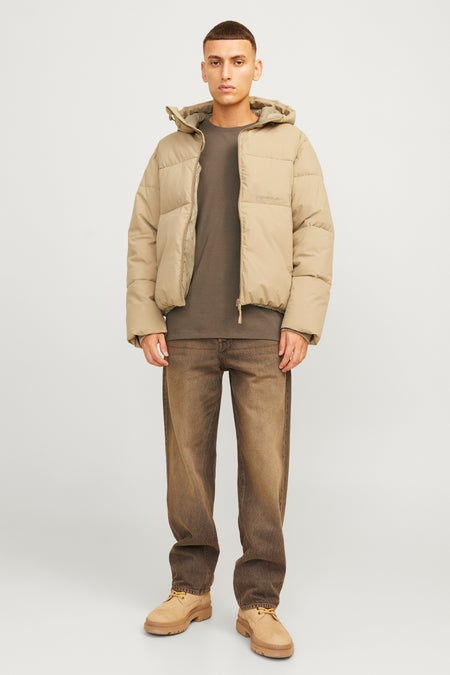 T-shirt à manches courtes marron de ORIGINALS BY JACK & JONES, porté sous une doudoune beige, avec un jean foncé et des bottes marron, vue de face.