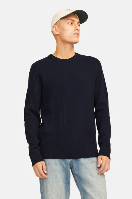 Donkerblauwe trui met ronde hals van CORE BY JACK & JONES, geribde textuur, gedragen met lichte jeans en een pet.

