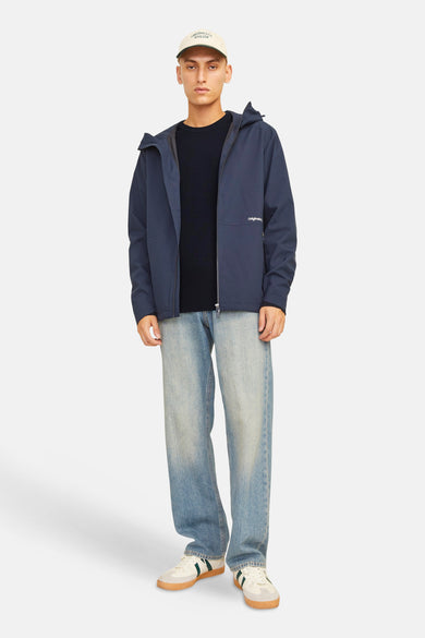 Donkerblauwe trui met ronde hals van CORE BY JACK & JONES, gedragen onder een marineblauw jack, met wijde jeans en sneakers.
