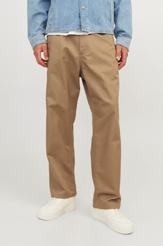 Beige broek van JACK & JONES JEANS INTELLIGENCE, gecombineerd met een lichtblauw denim jack en witte sneakers.
