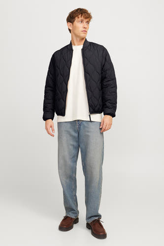 Zwarte korte jas van PREMIUM BLUE by JACK & JONES, met een ruitjespatroon en gedragen met een wit shirt en blauwe jeans.
