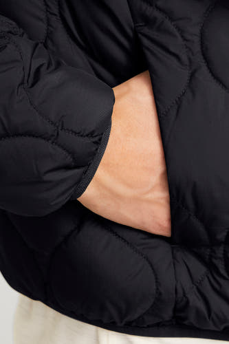 Zwarte korte jas van PREMIUM BLUE by JACK & JONES, met een hand in de zak.