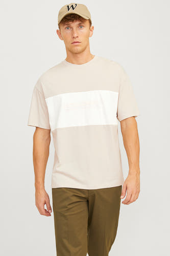 Beige T-shirt met korte mouwen van CORE BY JACK & JONES, met wit vlak en olijfgroene broek en pet.