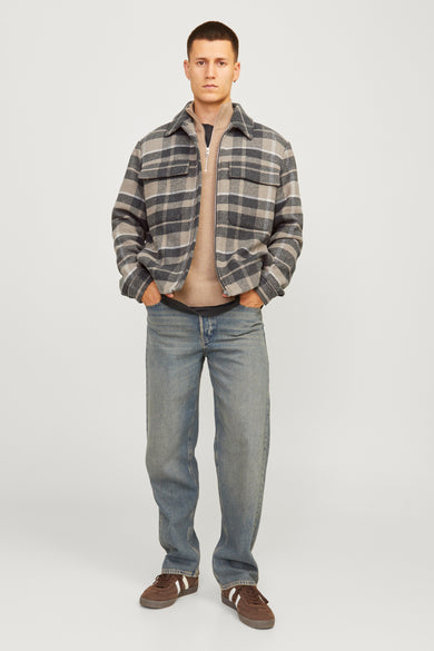 Korte bruine jas van PREMIUM by JACK & JONES, met een ruitpatroon en gedragen over een trui en jeans.
