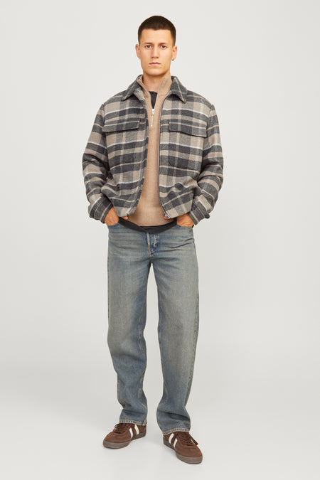 Korte bruine jas van PREMIUM by JACK & JONES, met een ruitpatroon en gedragen over een trui en jeans.
