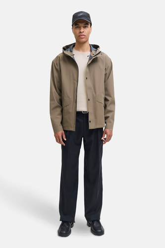 Beige trui met ronde hals van PREMIUM by JACK & JONES, gedragen met een kaki jas en zwarte broek.