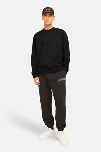 Zwarte sweater van ORIGINALS BY JACK & JONES, met lange mouwen, gecombineerd met een pet en joggingbroek.