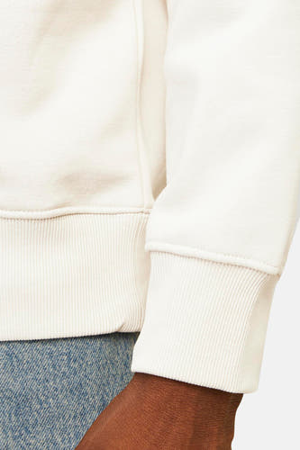 Gilet beige d'ORIGINALS BY JACK & JONES, avec des bordures et des manches côtelées, porté avec un pantalon de travail.