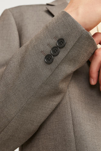 Grijze blazer van PREMIUM by JACK & JONES, met drie knopen op de mouw en een subtiele textuur.