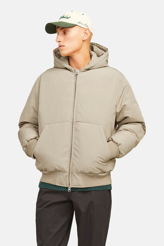 Beige korte jas van CORE BY JACK & JONES met subtiel rasterpatroon, capuchon, rits, geribde boorden en steekzakken, gedragen door een model met een pet.