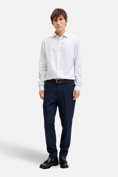 Wit overhemd met lange mouwen van PREMIUM by JACK & JONES, met zichtbare knoopsluiting en gedragen met donkerblauwe pantalon en leren riem.