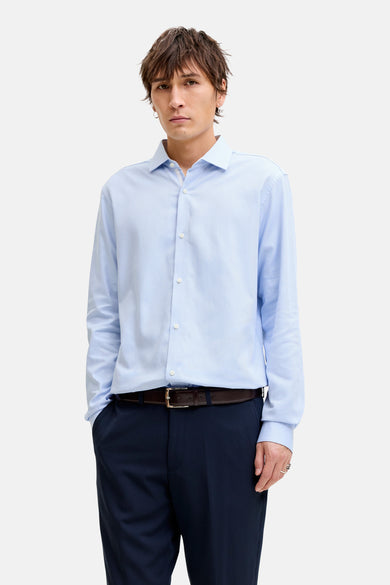 Chemise bleue à manches longues de PREMIUM by JACK & JONES, portée avec un pantalon foncé et des chaussures en cuir.