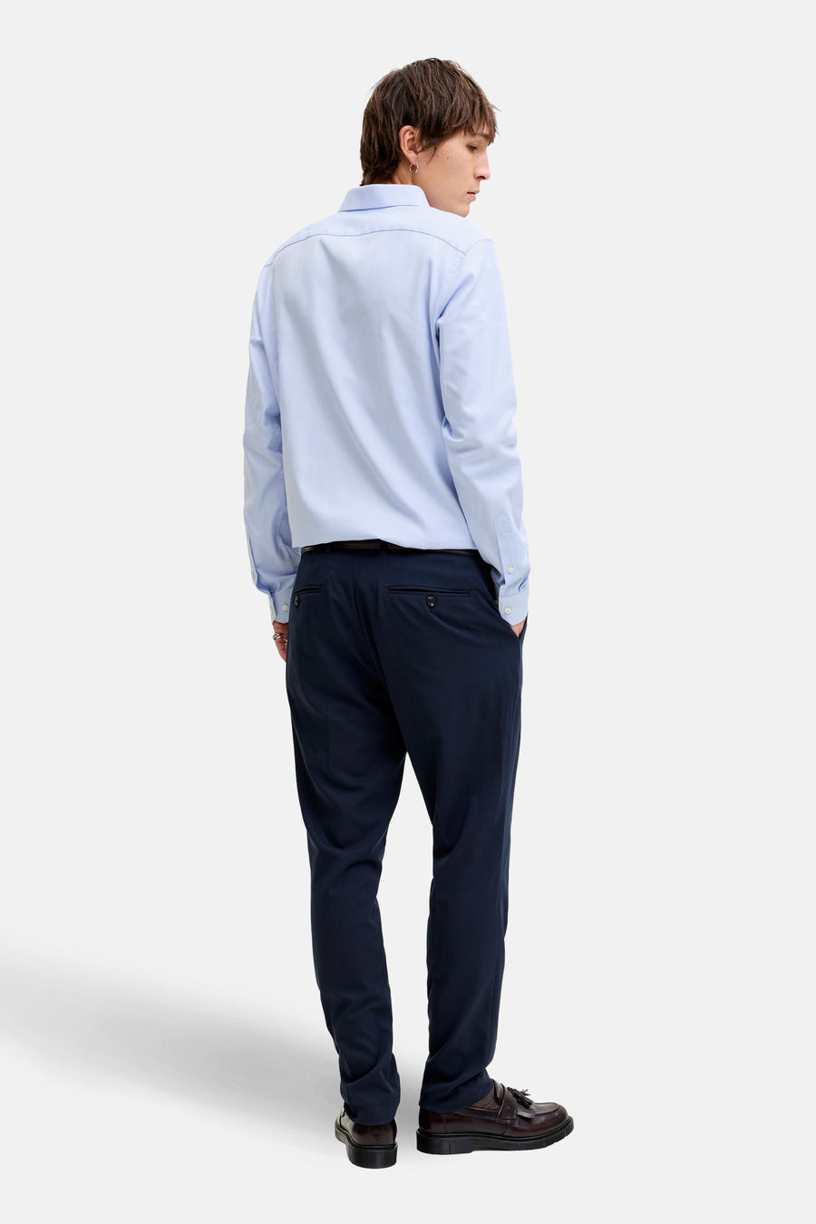 Chemise bleue à manches longues de PREMIUM by JACK & JONES, avec col boutonné et portée avec un pantalon foncé et des chaussures en cuir.