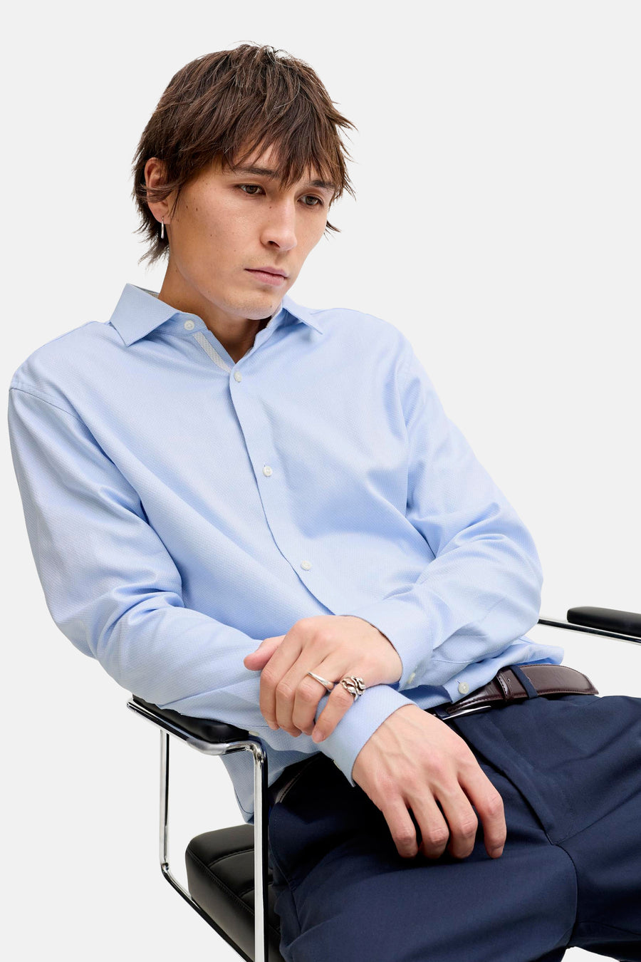 Chemise bleue à manches longues de PREMIUM by JACK & JONES, portée avec un pantalon foncé et une ceinture dans un style formel.
